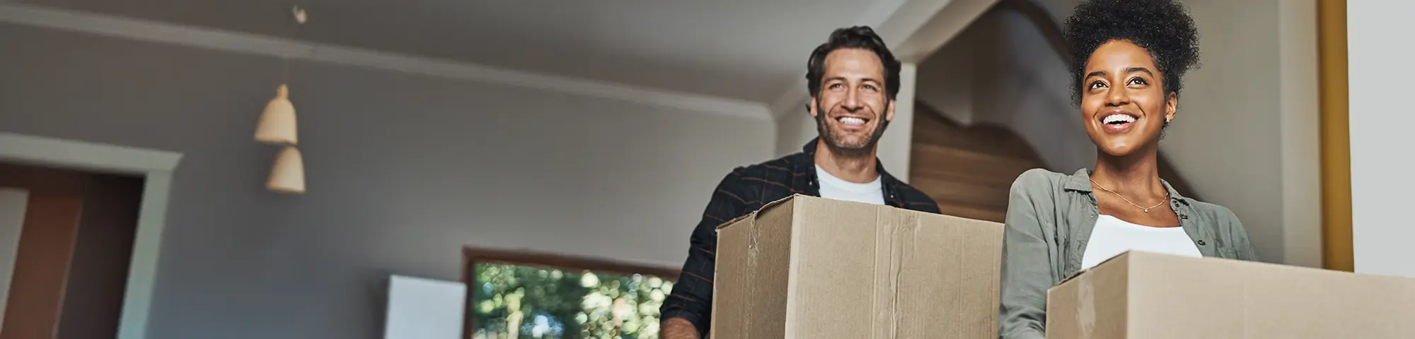 photo of a couple carrying boxes for moving